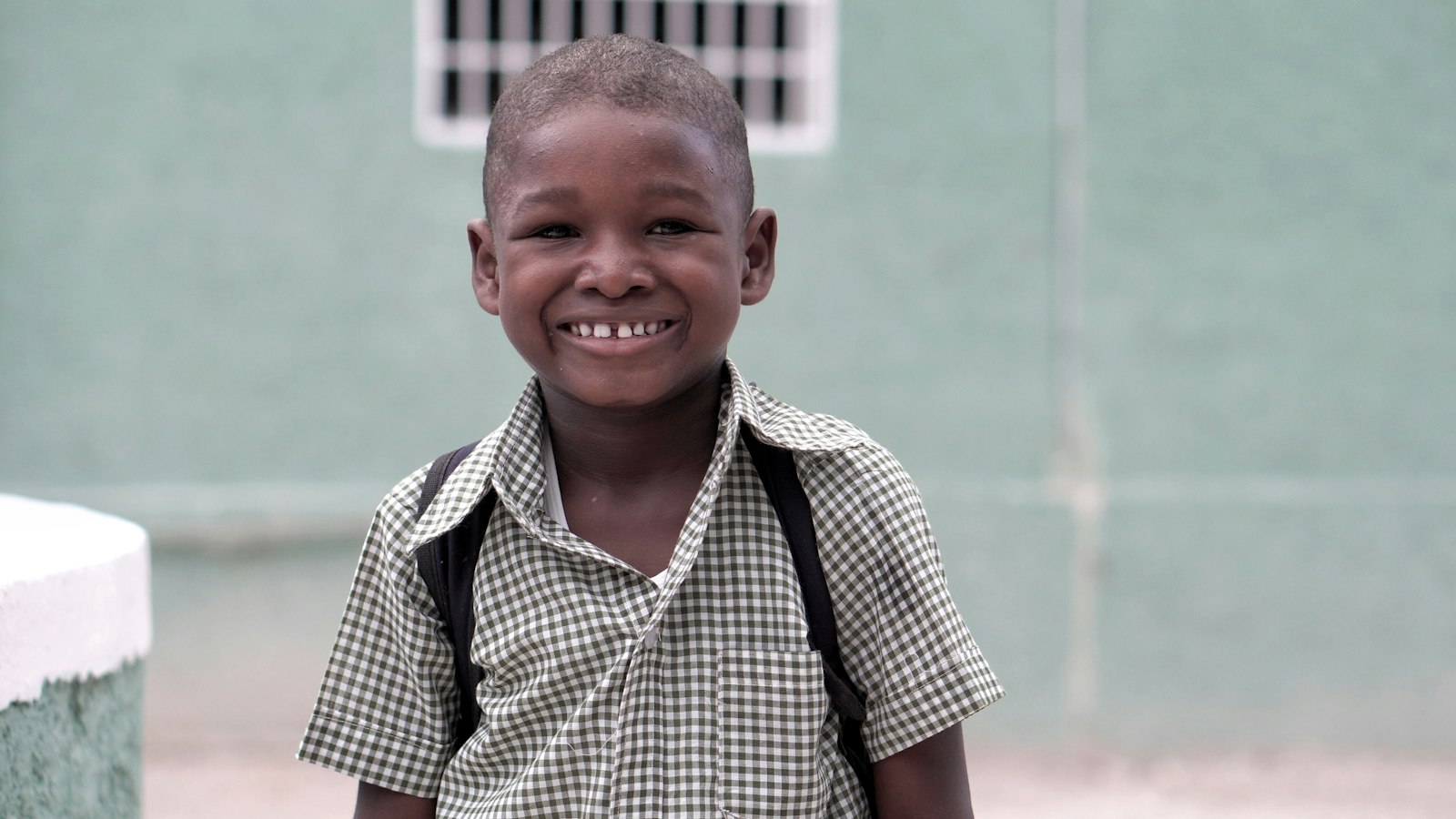 Boy smiling, wearing a backpack